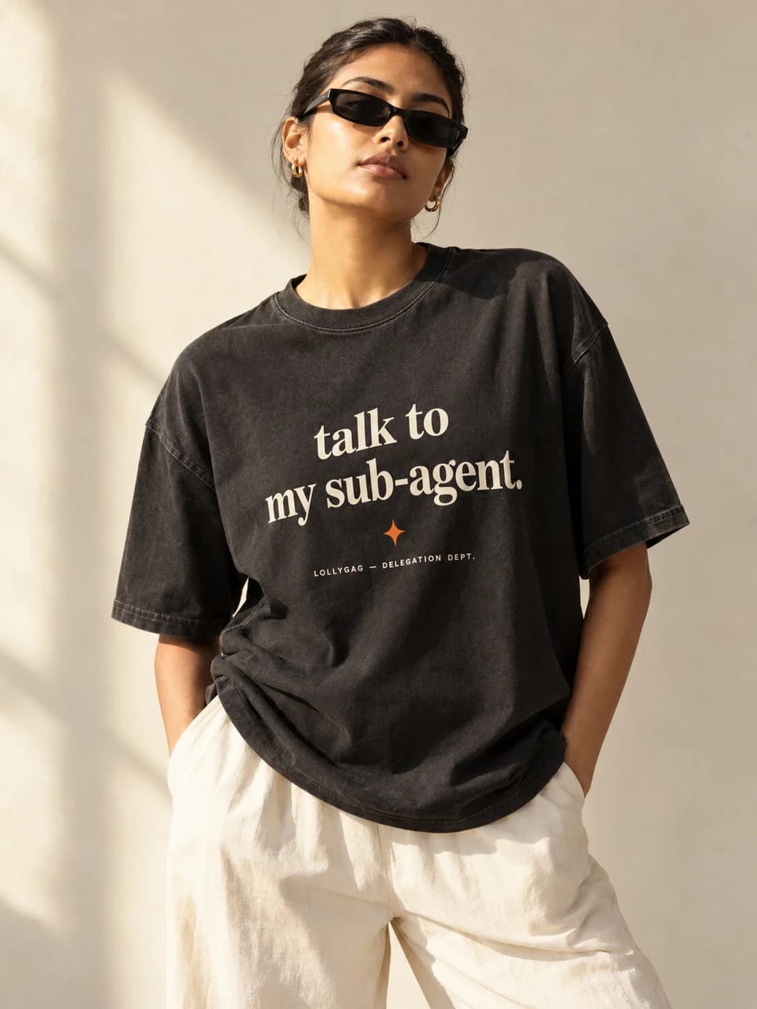 Lollygag oversized Talk to my sub-agent tee, styled with sunglasses and cream trousers